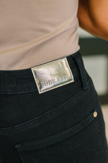 Close-up of black pants with a metallic label on the waistband.