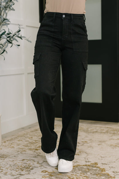 Person wearing black cargo pants with a neutral background