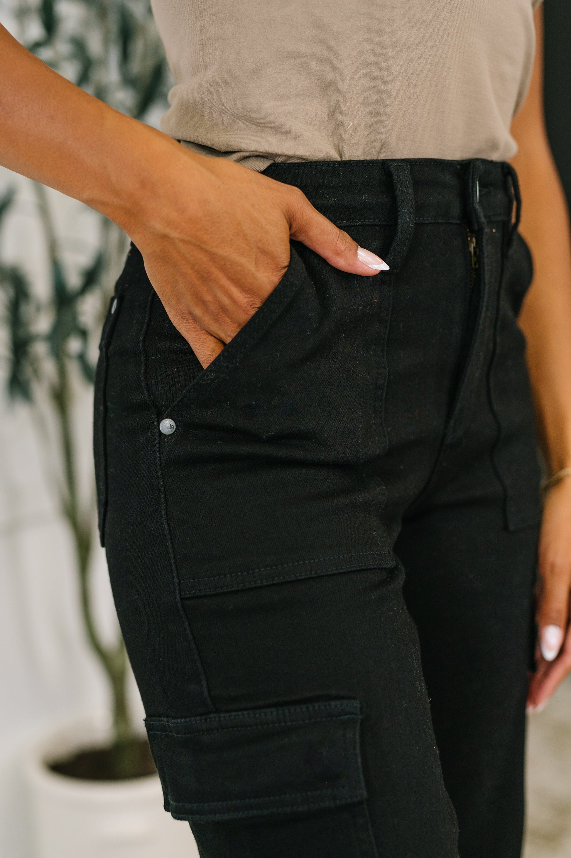 Person wearing black cargo pants with a blurred background